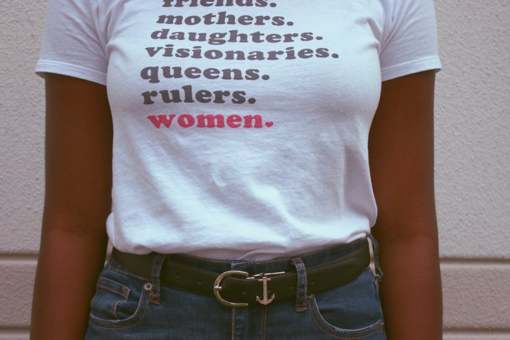 A woman stands in a t-shirt with a quote about empowerment